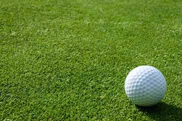 Side view of golf ball on a putting green
