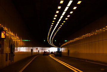 cars driving through a tunnel under the city