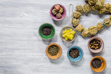 Tea-party with different herbal tea on gray wooden desk background flat lay mock up