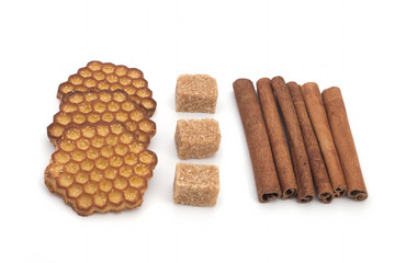 Biscuits, cane sugar, cinnamon sticks on white background