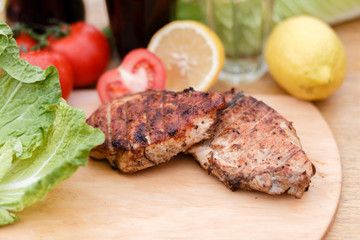 Сhicken breast grilled on a wooden Board. Chicken chili steak on the background with vegetables and black soda and lemonade, food photography