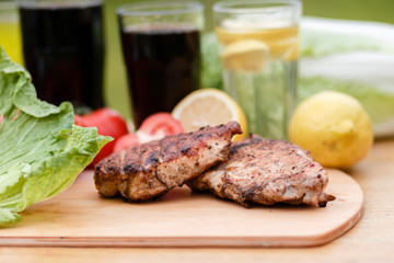 Сhicken breast grilled on a wooden Board. Chicken chili steak on the background with vegetables and black soda and lemonade, food photography