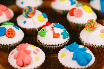 Baby cupcakes on the wooden background.