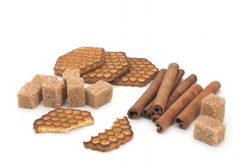 Biscuits, cane sugar, cinnamon sticks on white background