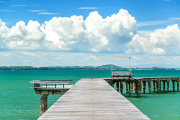 Wooden bridge on the sea with blue sky