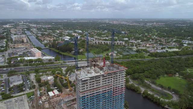 Aerial cinematic flyover construction site cranes