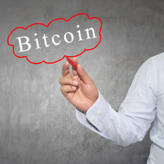 Hand of businessman drawing a word Bitcoin text.