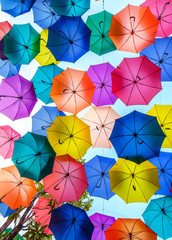 Multi-colored umbrellas background. Colorful umbrellas floating above the street. Street decoration. © somchairakin