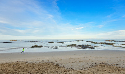 Woman running on tropical beach taken with wide angel lens
