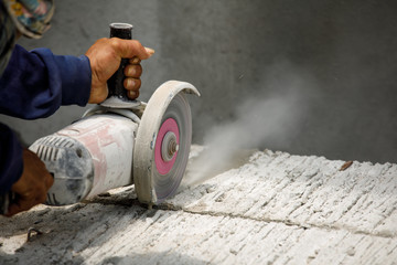 Worker using tool to cut concrete floor