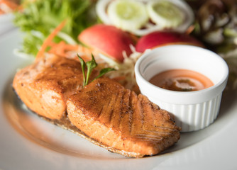 Chicken steak with sauce and vegetable in background