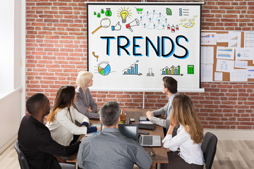 Businesspeople Looking At Trends Presentation