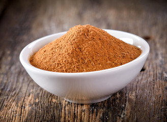 Cinnamon powder in a bowl on table wooden