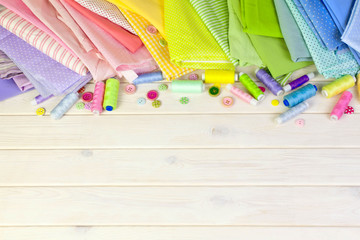 Accessories for sewing lie on a white background. Measuring tape, thread, fabric, needle bar and...