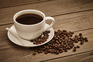 Fototapeta premium Cup of coffee and coffee beans with wooden table