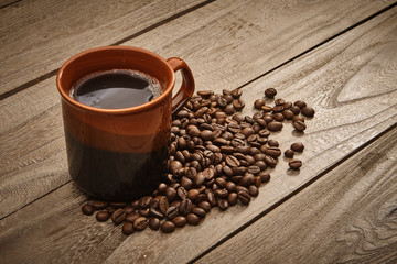 Cup of coffee and coffee beans with wooden table