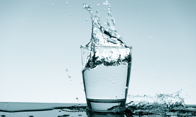 Fototapeta na wymiar Water splash in glass. Drinking water concept
