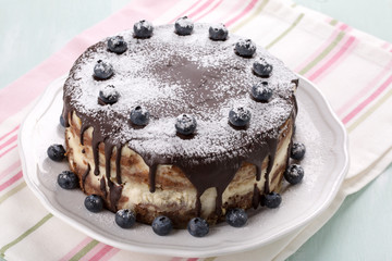 Homemade  layered  cake with chocolate icing decorated with blueberries