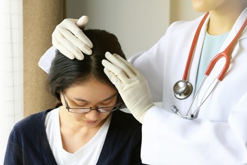 Female doctor looking at patient's hair and scalp, Dermatologist exam scalp disorder. - obrazy, fototapety, plakaty