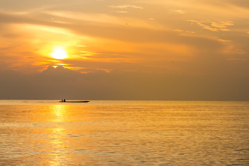 Naklejka na ściany i meble Silhouette fishing boat and Reflection of sunlight on the sea, sunrise in the sea