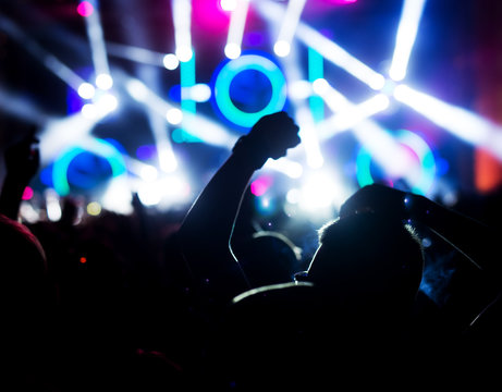 Blurred image, in motion out of focus. Music festival concept. Crowd dancing at night.
