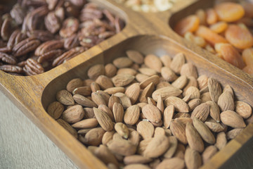 Assorted organic nuts and dried fruits in wooden box
