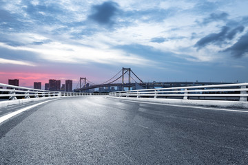 empty road with suspension bridge in modern city
