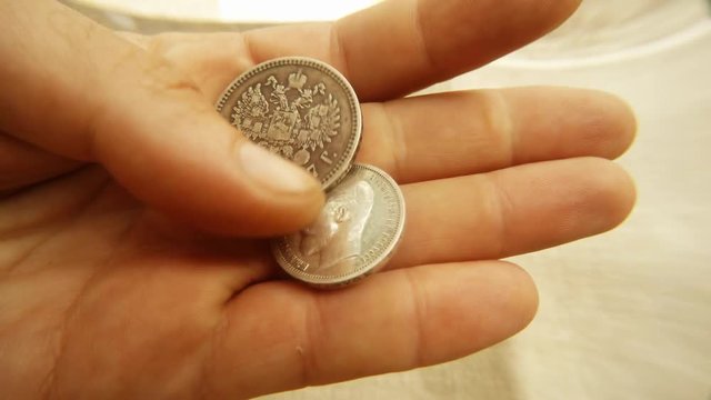 Hand Turn Fifty Silver Kopecks and One Silver Ruble Reverse Obverse Hide in Fist Close up