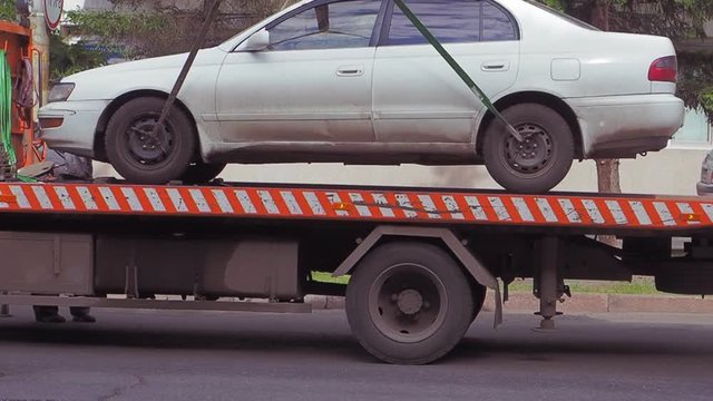 The tow truck lifts and loaded the car.