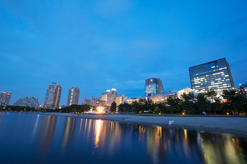 Fototapeta premium modern buildings near water at night