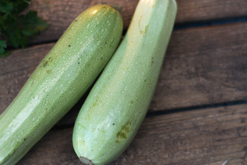 Fresh zucchini on a wooden old background with vegetables.