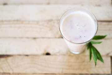 Milk shake yogurt with strawberry slices on a wooden background.