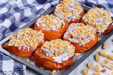 cinnamon rolls with peanuts on baking sheet