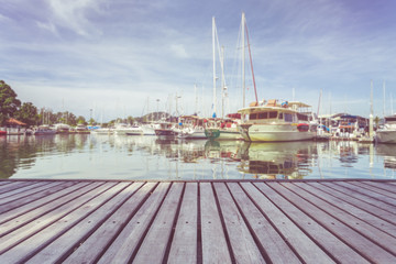 Wooden decking or walkway and view of yacht standing at the marina.
