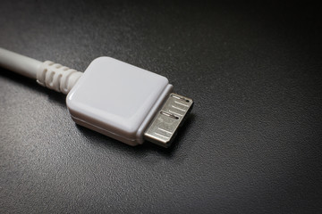 White usb 3.0 cable with micro B connector on black background close up image