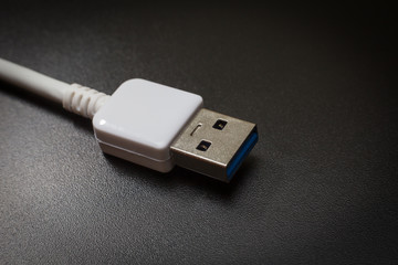 White usb 3.0 cable with micro B connector on black background close up image