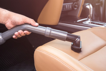 Hand of people holding vacuum cleaner and cleaning inside the SUV car