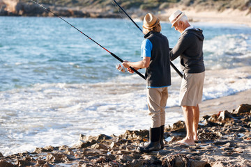 Fototapeta na wymiar Senior man fishing with his grandson