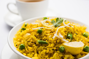 Indian Breakfast Dish Poha Also Know as Pohe or Aalu poha made up of Beaten Rice or Flattened Rice. The rice flakes are lightly fried in oil with mustard, chilly, onion, curry leaves and turmeric © StockImageFactory