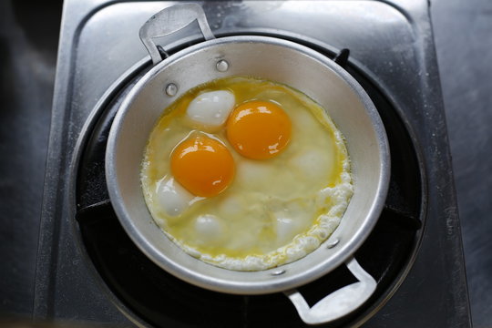 Fried eggs in pan.