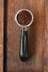 Freshly ground coffee beans in a metal filter for background