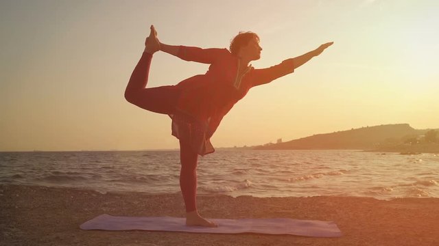 yoga at sunset on the beach. woman doing yoga, performing asanas