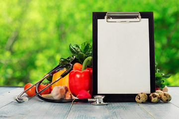 Clipboard with stethoscope and set of different vegetables