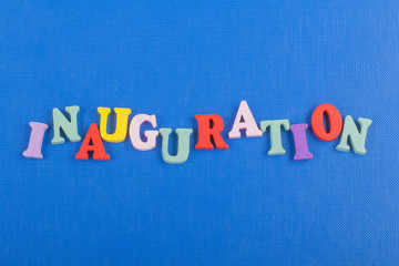 Fototapeta na wymiar Iinauguration . English word on blue background composed from colorful abc alphabet block wooden letters, copy space for ad text. Learning english concept.