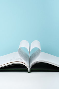 Old open hardback book, page decorate into a heart shape for love in Valentine's. love with open book heart.