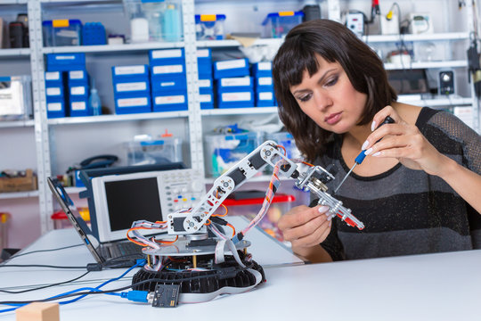 Female In Robotics Laboratory. Young Woman Experiment With Robot