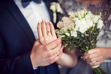 Wedding bouquet and hands with rings