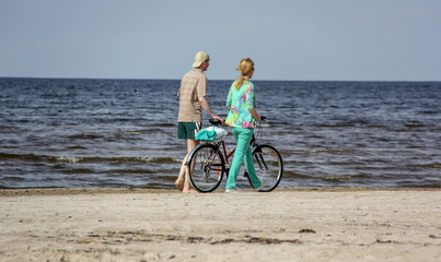 unknown people ride a bicycle along the sea