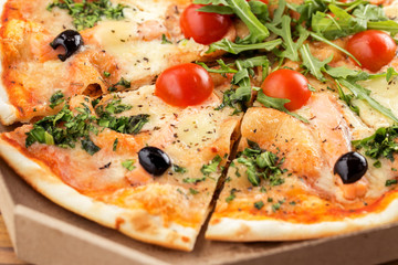 Italian pizza with salmon, cherry tomatoes, arugula and cheese