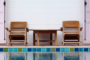 Wooden chair on ground beside swimming pool